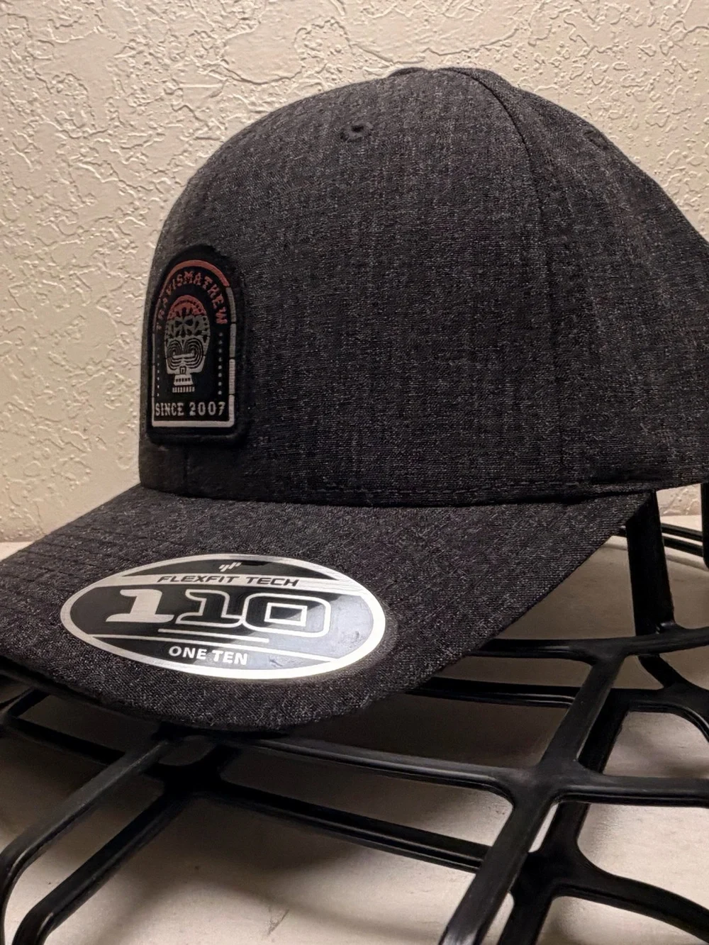 Travis Mathew Dark Gray Patch Baseball Cap with Black and White Logo